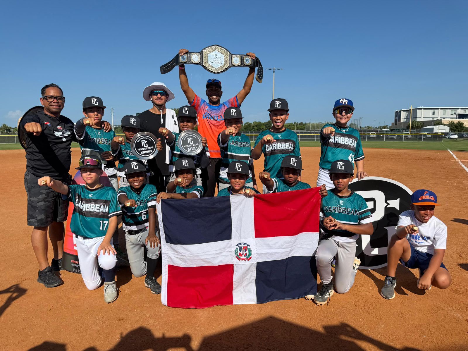 John Carmona, Leo Mercedes y los infantes campeones exhiben la faja y anillos de campeones.