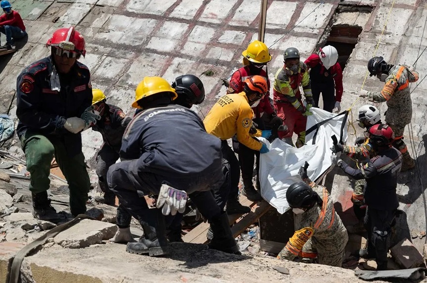 Fotografía de rescatistas recuperando un cuerpo de los escombros de un edificio afectado por los terremotos, este miércoles, en La Guaira (Venezuela).