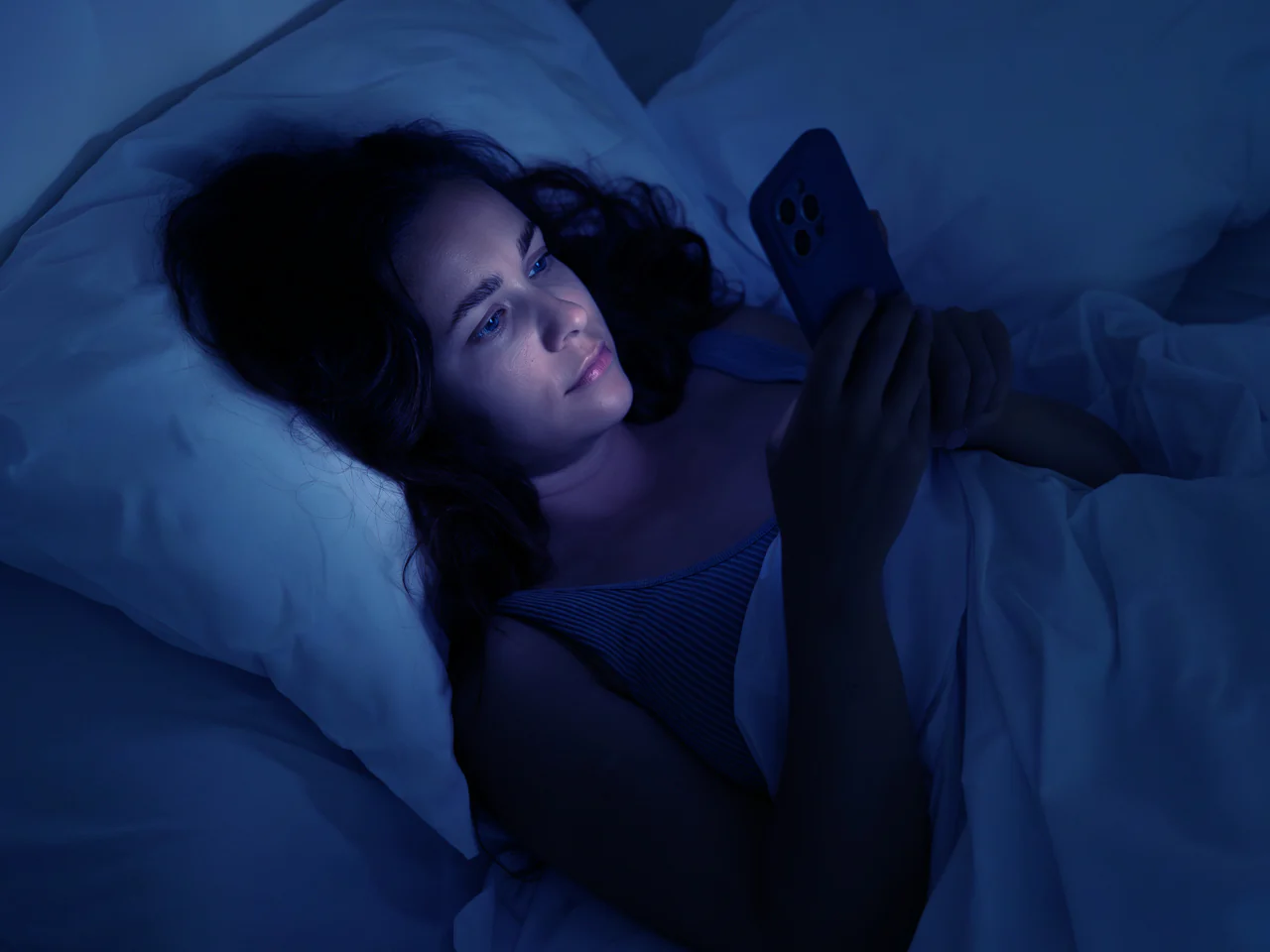 Una niña usa su teléfono por la noche.
