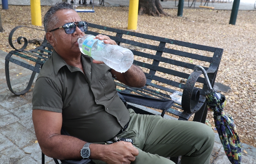 Víctor Díaz consume agua en medio del calor.