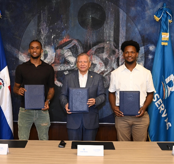 Leonardo Aguilera, presidente del Banco de Reservas, al momento de firmar el acuerdo de imagen con los baloncestistas Jean Montero y Andrés Féliz.