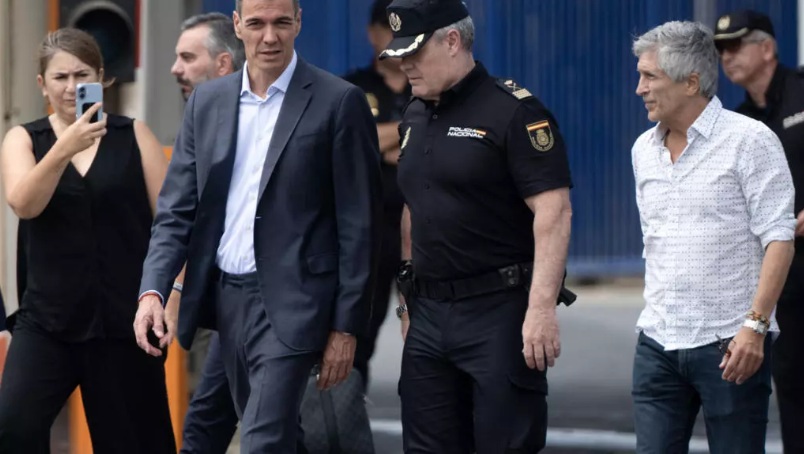 El primer ministro de España, Pedro Sánchez (C), y el ministro del Interior, Fernando Grande Marlaska (D), caminan junto a la valla fronteriza de Tarajal, entre el enclave español de Ceuta, en el norte de África, y Marruecos, durante una visita para gestionar una de las mayores crisis migratorias en la frontera del país, tras el cruce de miles de migrantes desde Marruecos durante la noche del 31 de julio de 2026. AFP - JORGE GUERRERO