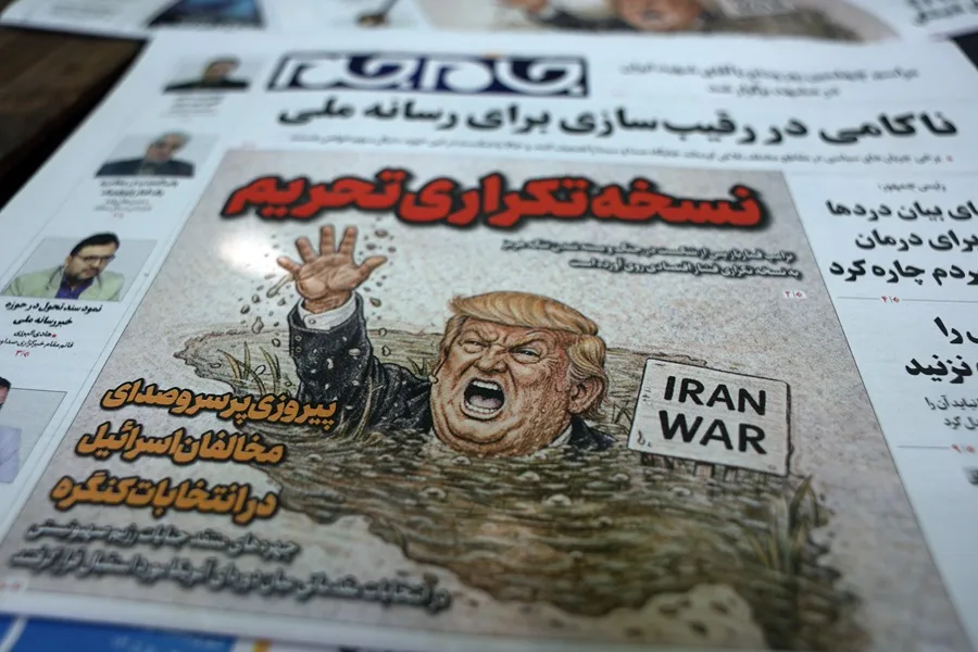 Copias del diario iraní 'Jame-Jam' con una caricatura del presidente de EE.UU., Donald Trump, y un titular en persa que dice 'Versión Duplicada de Sanciones' informando sobre la nueva amenaza económica contra Irán, junto a un quiosco en Teherán. EFE/EPA/ABEDIN TAHERKENAREH