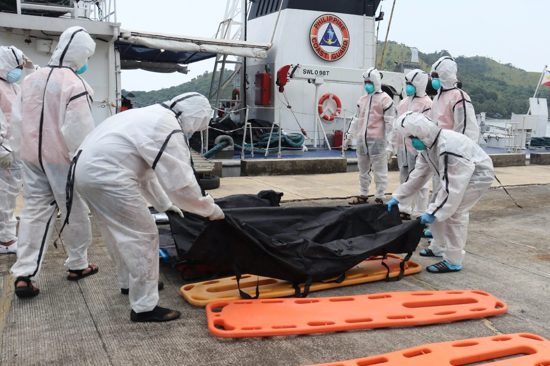 Efectivos de los guardacostas filipinos trasladan los restos mortales de las personas fallecidas en un incendio de un barco de pasajeros