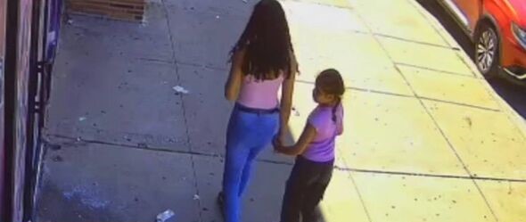 La niña caminaba junto a una pariente.