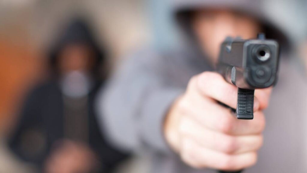 Hombre con un arma de fuego en la mano.